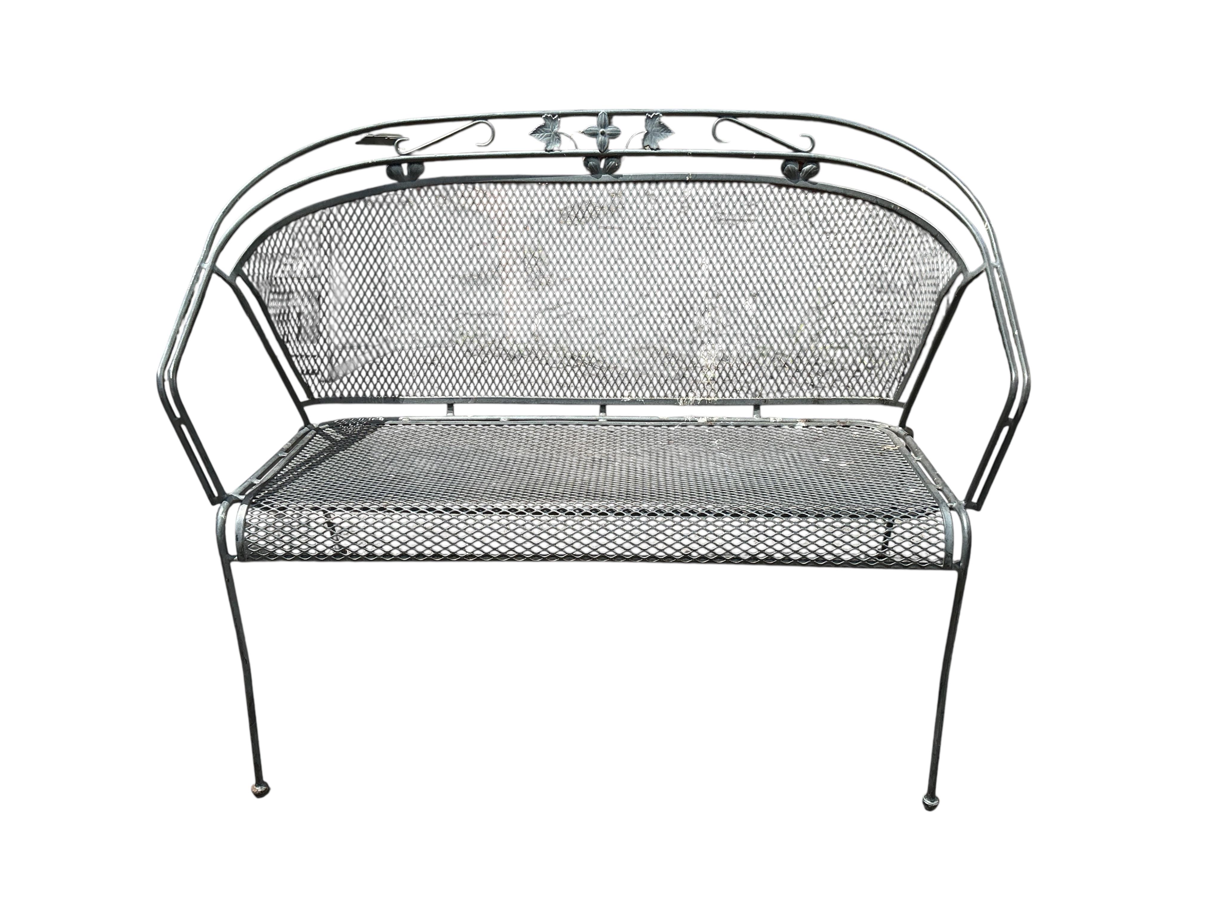 A wrought iron garden bench and ten matching garden chairs